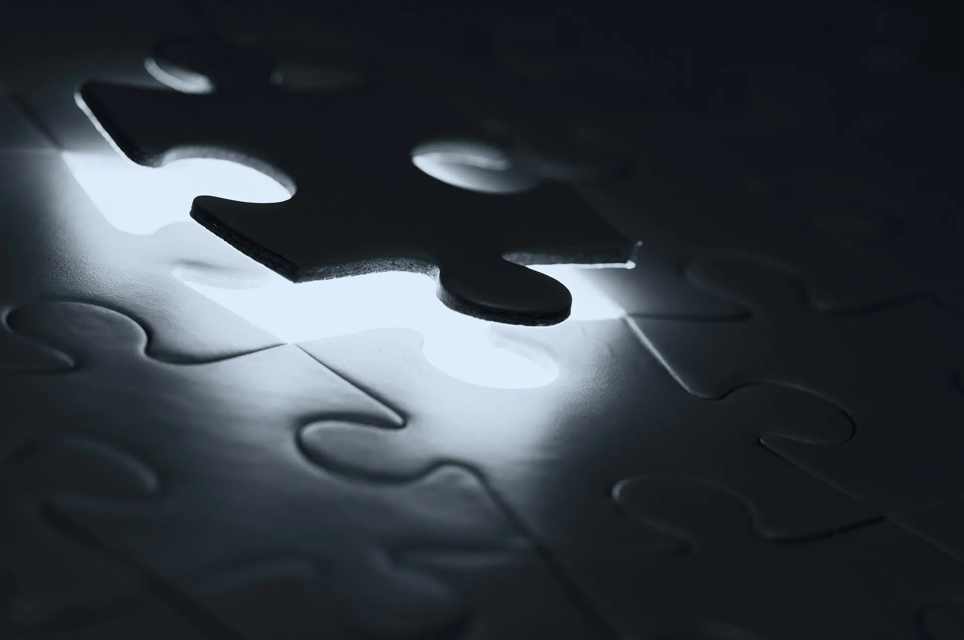 A single dark puzzle piece hovering above a matching empty slot